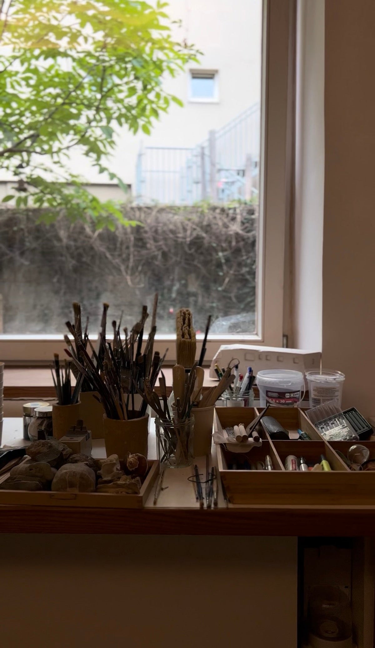 studio work table by the window — brushes and tools