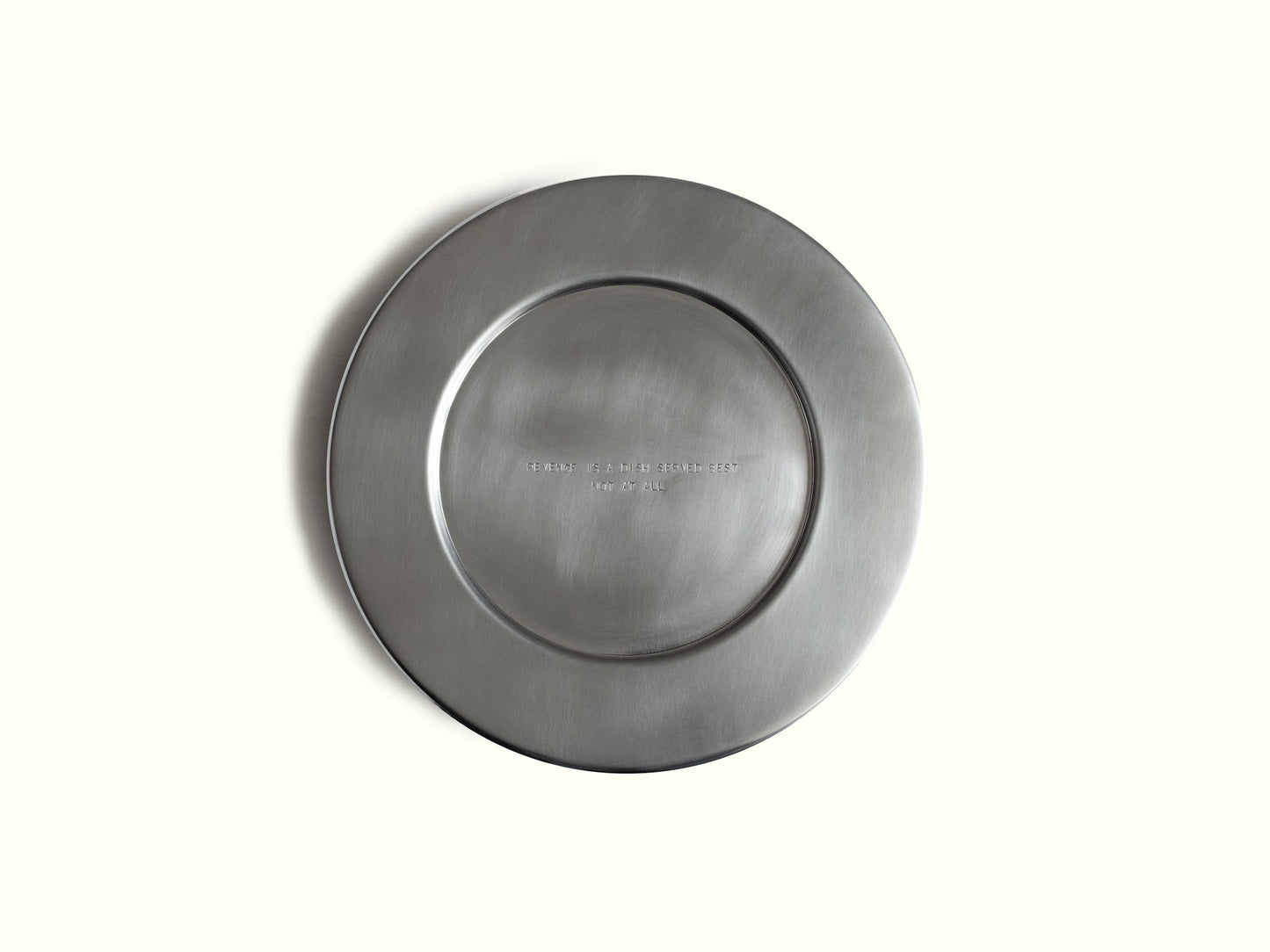 traces charging plate 'revenge' — brushed aluminium, engraved 'revenge is a dish served best, not at all' · studio von schoenebeck · collectible design at spazio